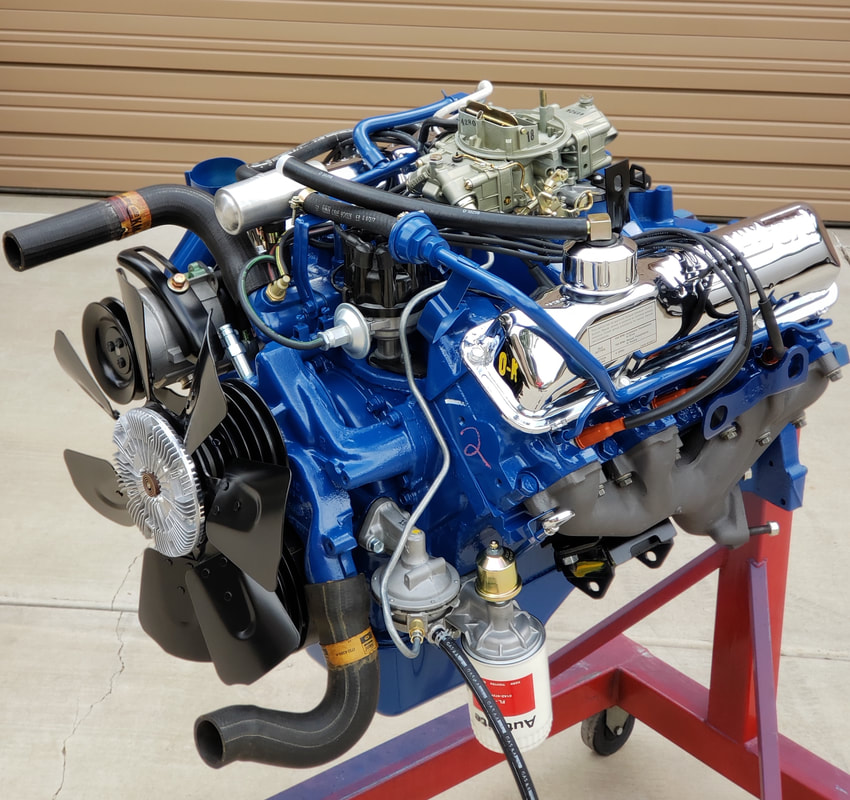 A detailed view of a blue vintage car engine on a stand.