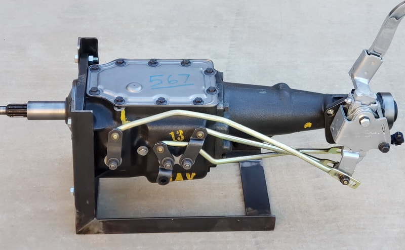 A mechanical device with cables attached, mounted on a black base.