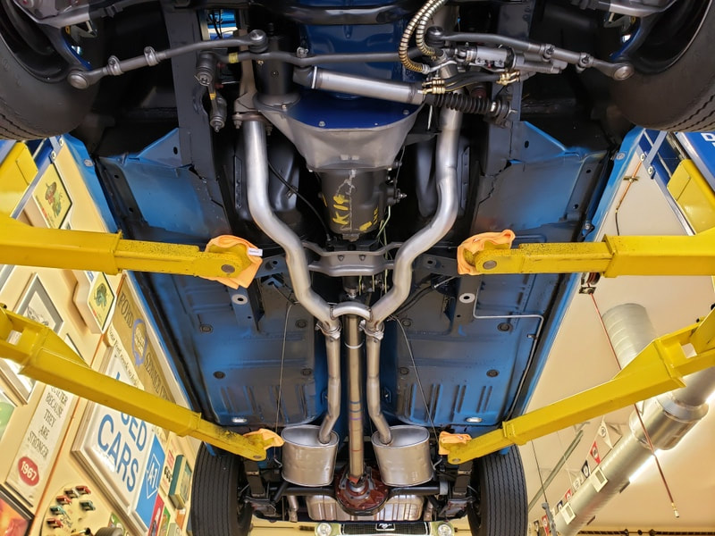 Undercarriage view of a vehicle showing the exhaust system and suspension components.