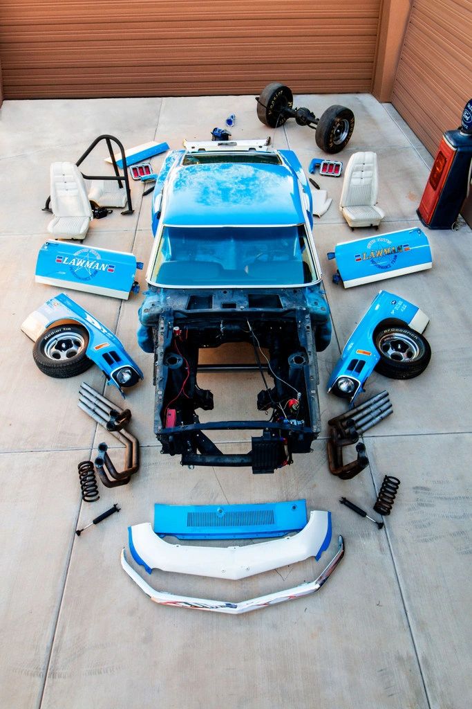 Disassembled car parts arranged on the floor.