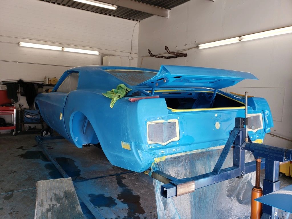 Blue vintage car being restored in garage.