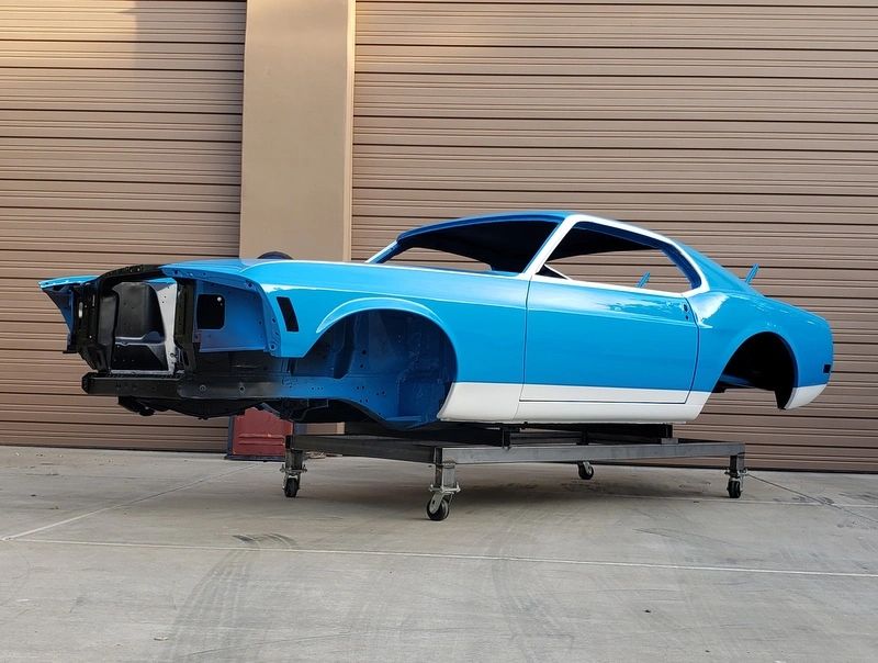 Blue classic car body on stand.