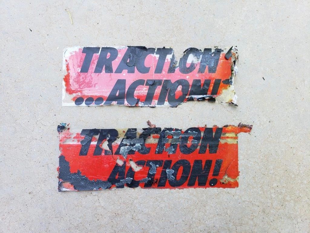 Two weathered "Traction Action" stickers.