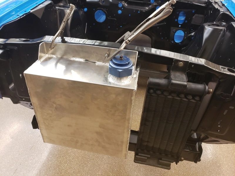 Car engine bay with metal tank installation.