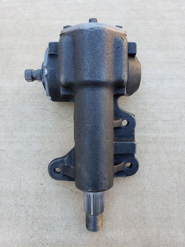 Metal steering gearbox on concrete surface.