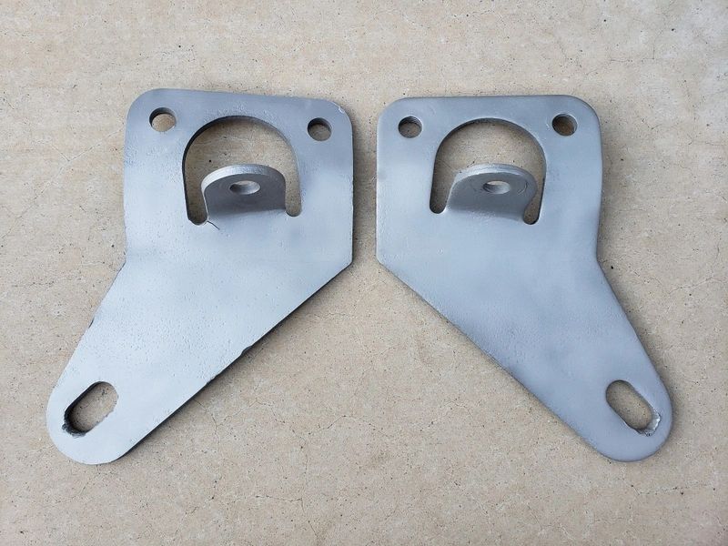 Two metal brackets on a flat surface.