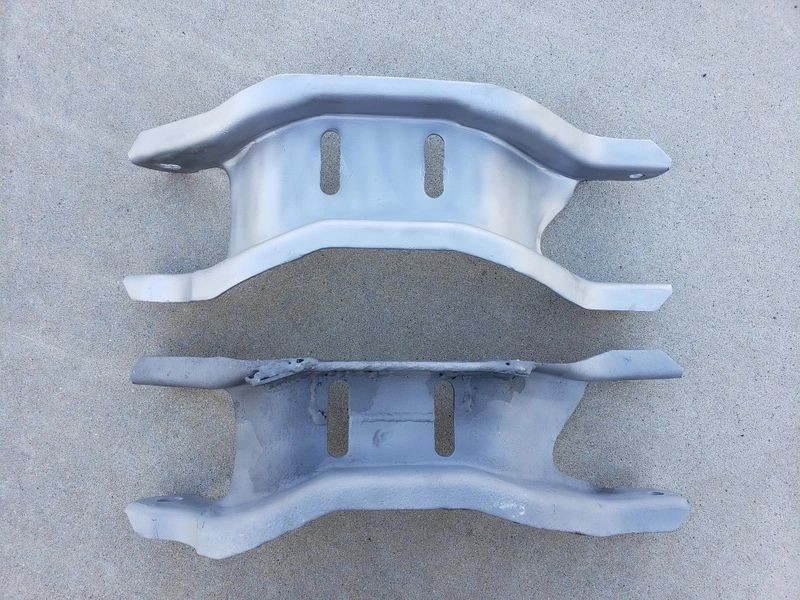 Two metal brackets on a concrete surface.