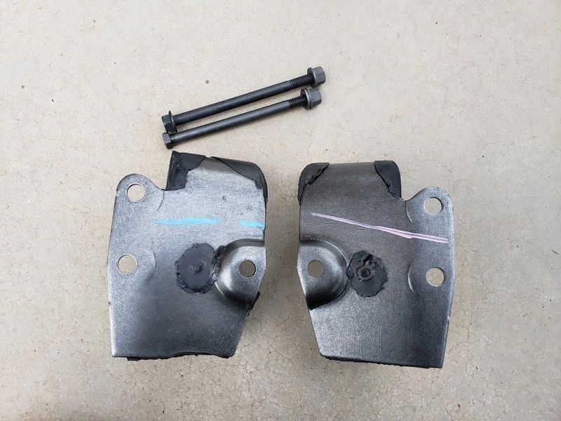 Metal brackets and bolts on concrete surface.