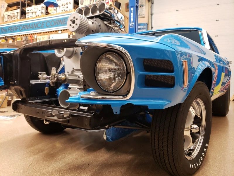 Blue vintage car with exposed engine parts.