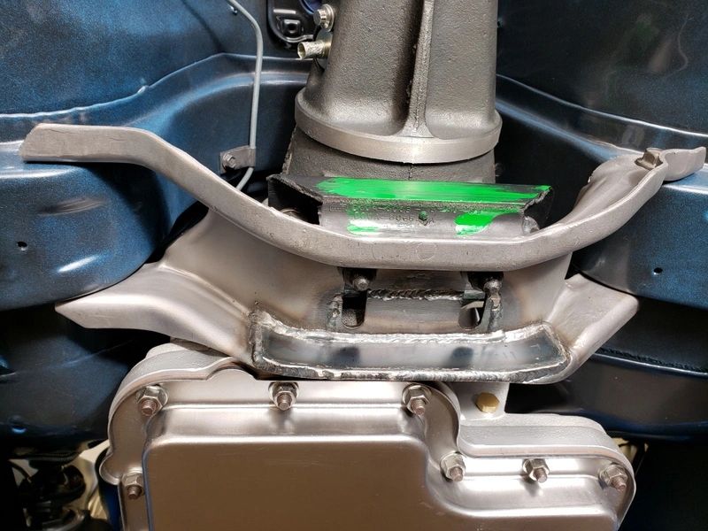 Car transmission mount with green marking.