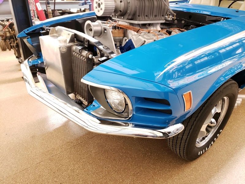 Blue vintage car with exposed engine components.