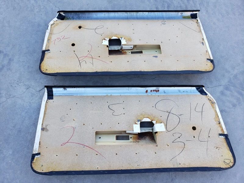 Two vintage car door panels with markings.