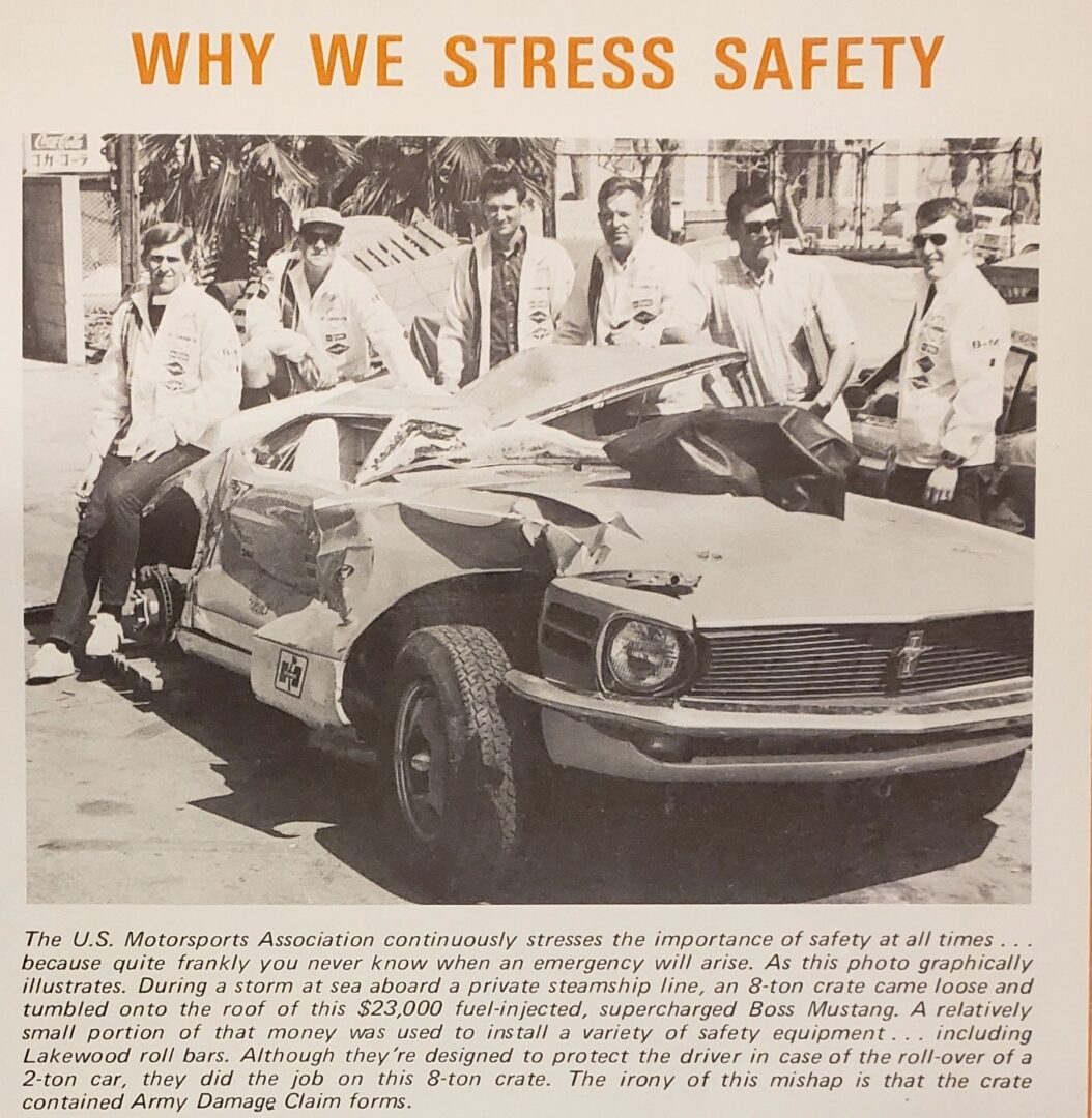 Damaged car with people standing behind it.