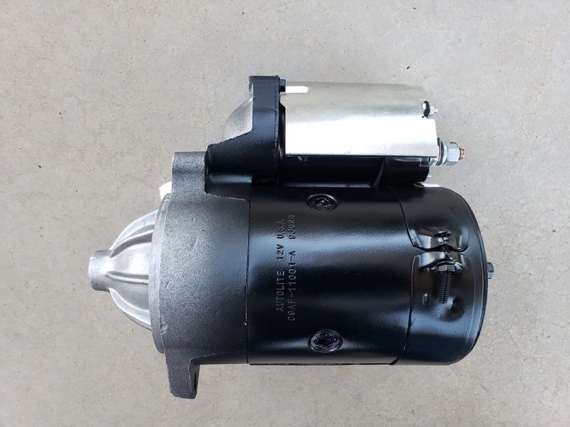 Automotive starter motor on gray background.