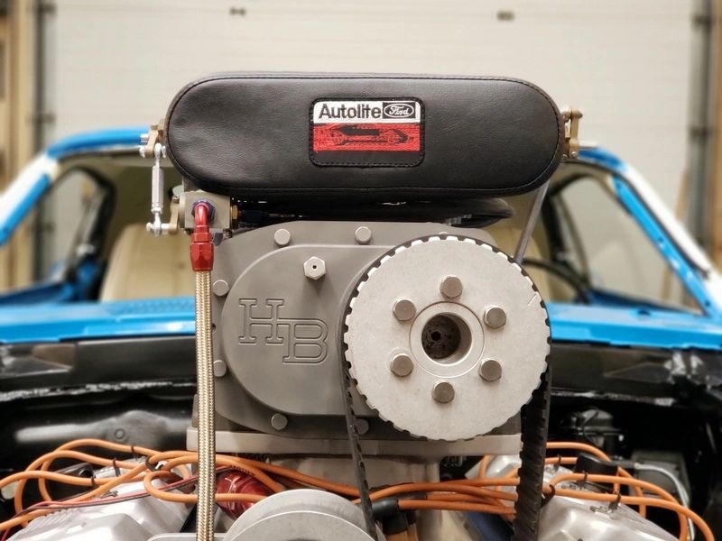 Car engine with Autolite logo, blue vehicle.