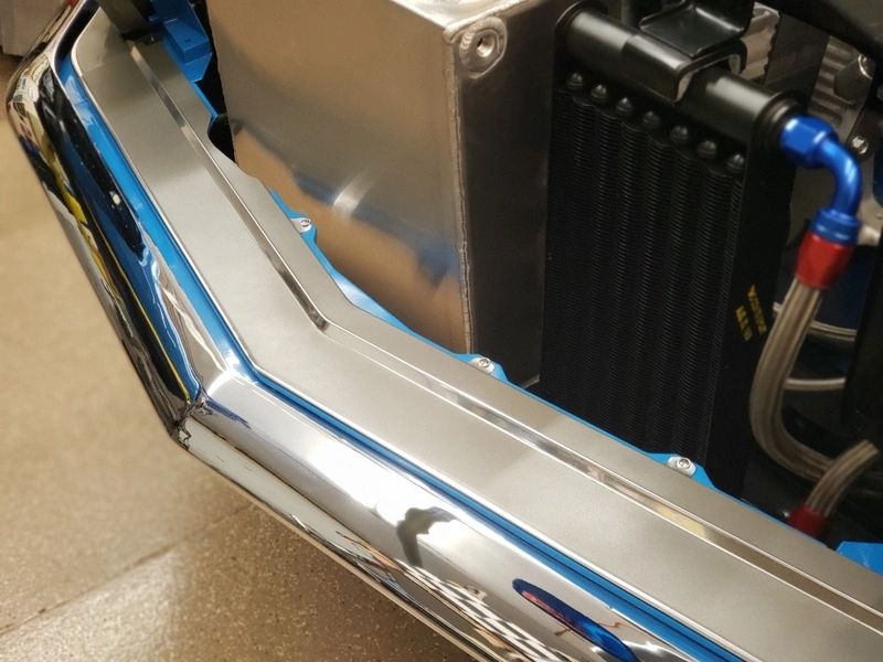 Car engine with chrome and metal components.