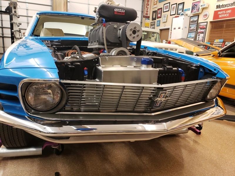 Vintage blue car with exposed engine.