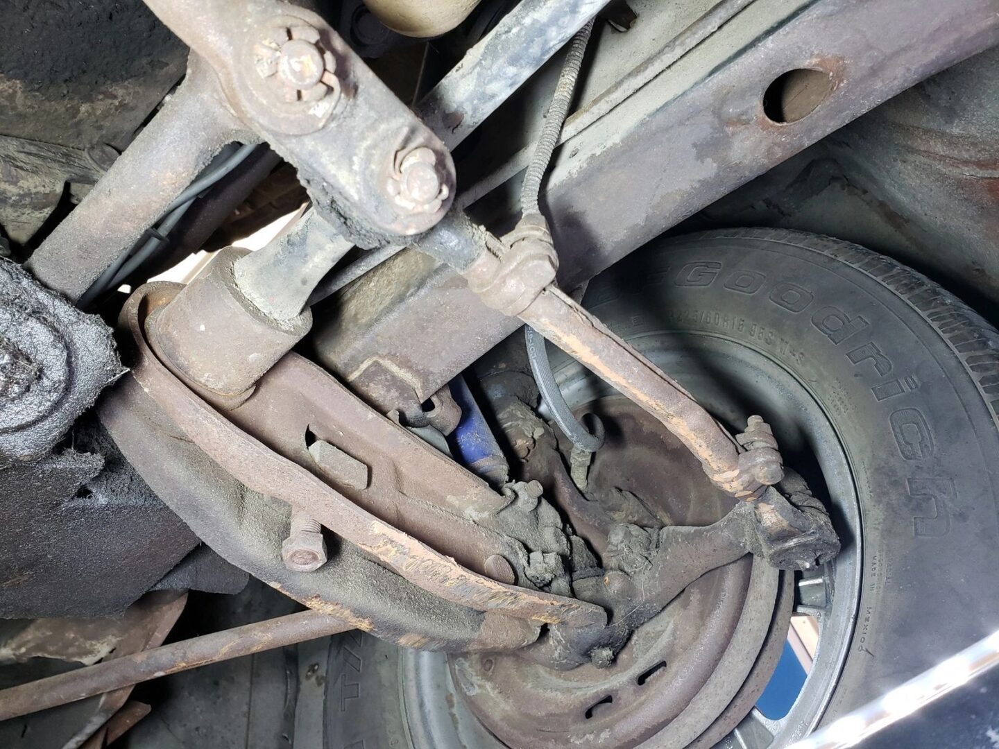 Rusty car suspension and tire close-up.
