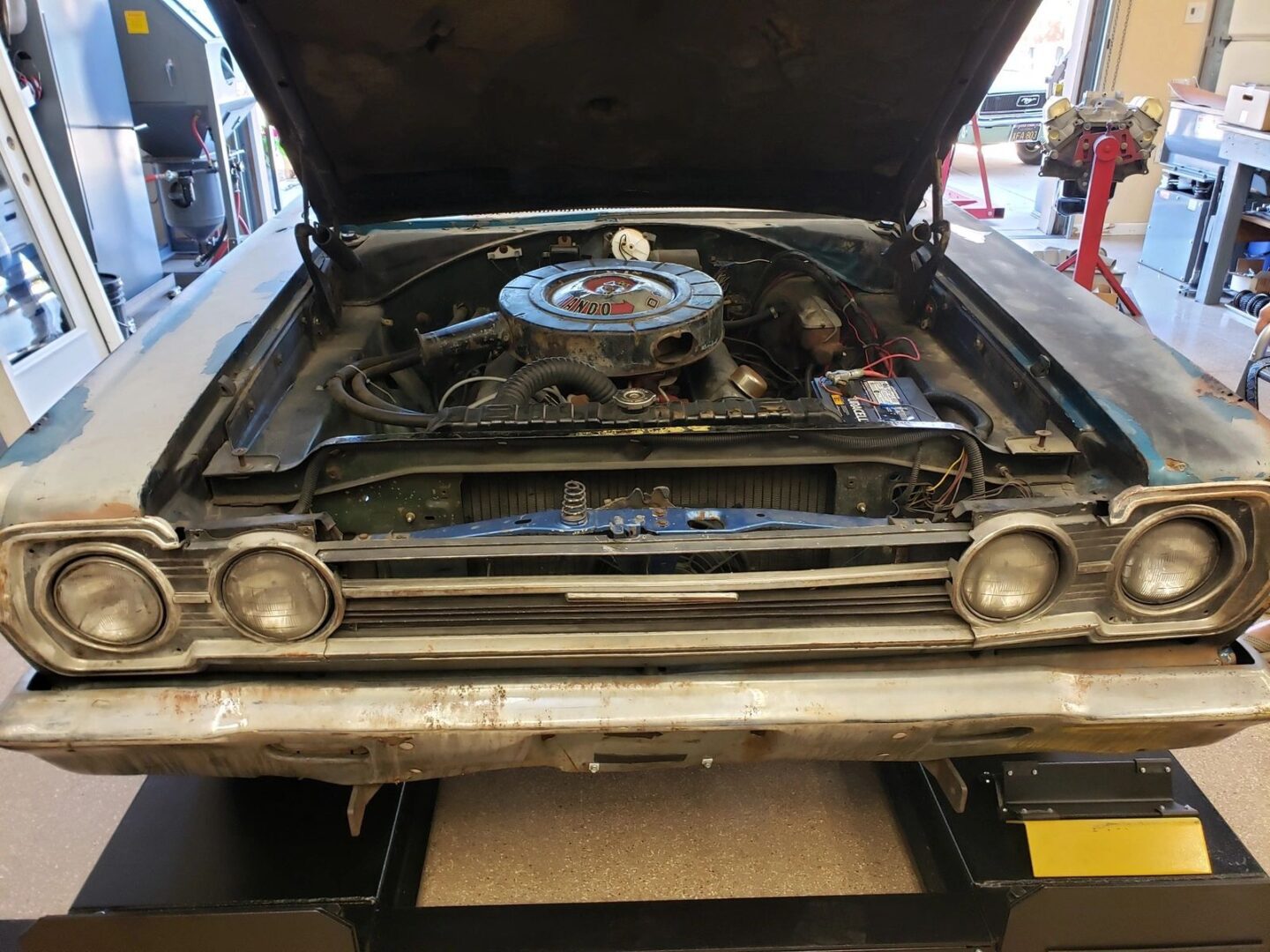 Classic car with hood open in garage.