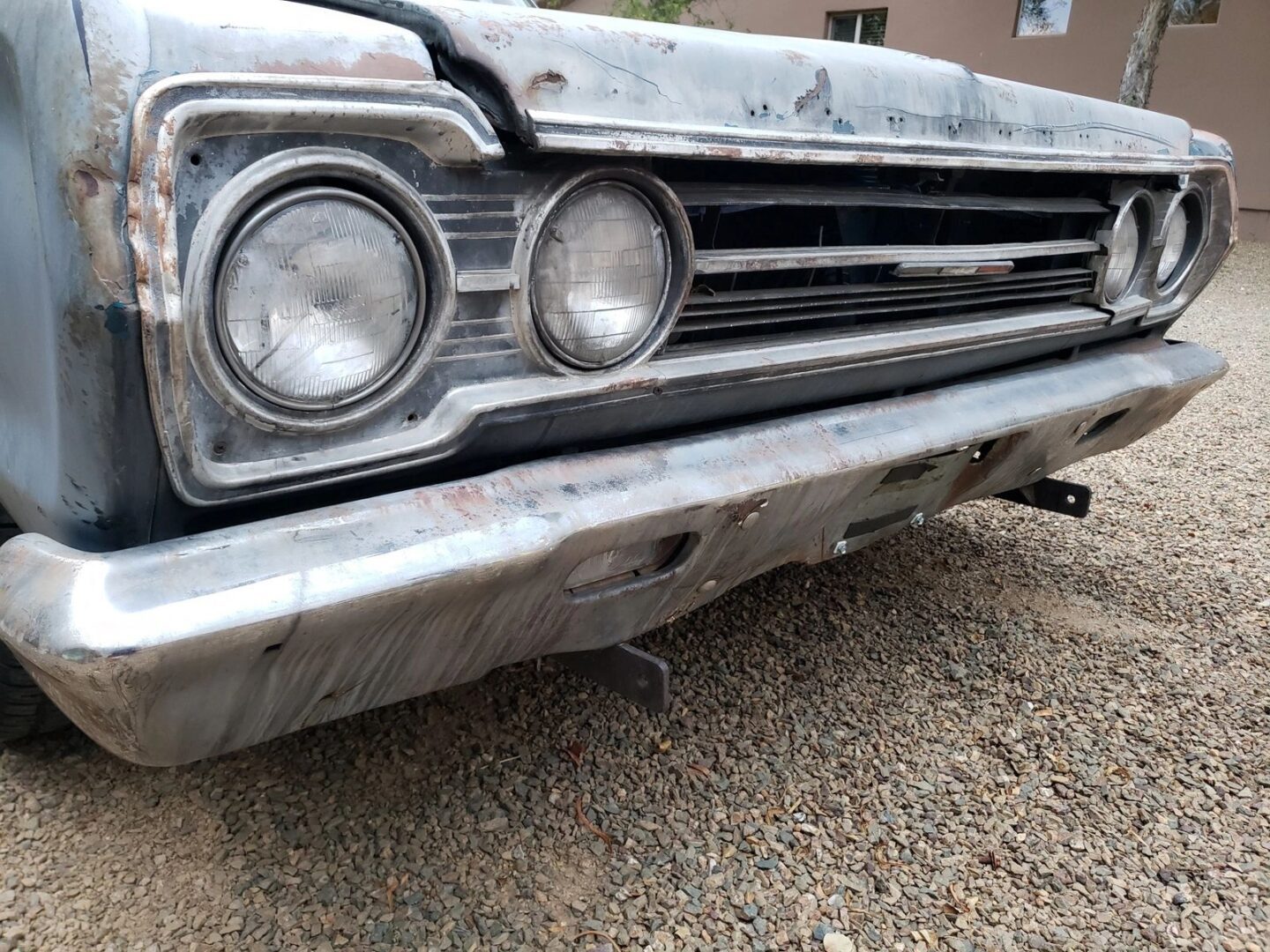 Vintage car front with dual headlights.