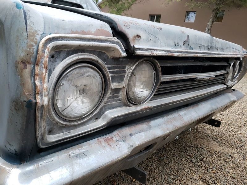 Close-up of a vintage car's rusty grille.