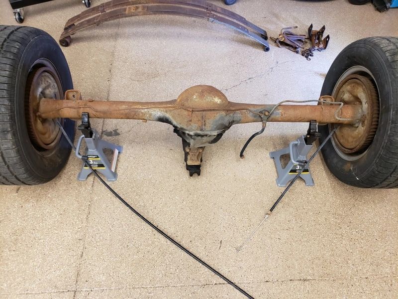 Car axle on jack stands in garage.