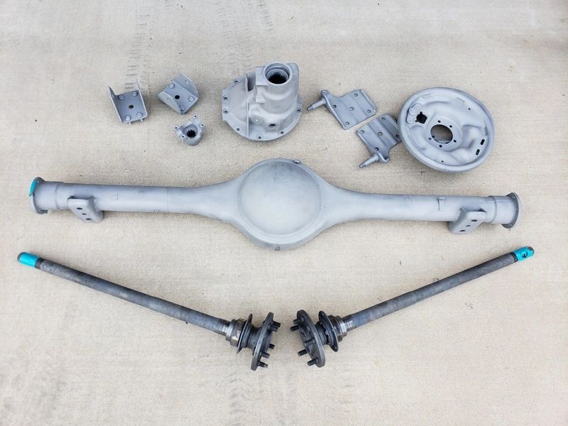 Car parts arranged on a concrete surface.