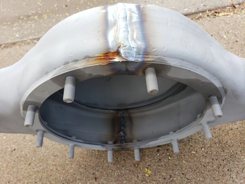 Metallic structure with bolts and weld marks.