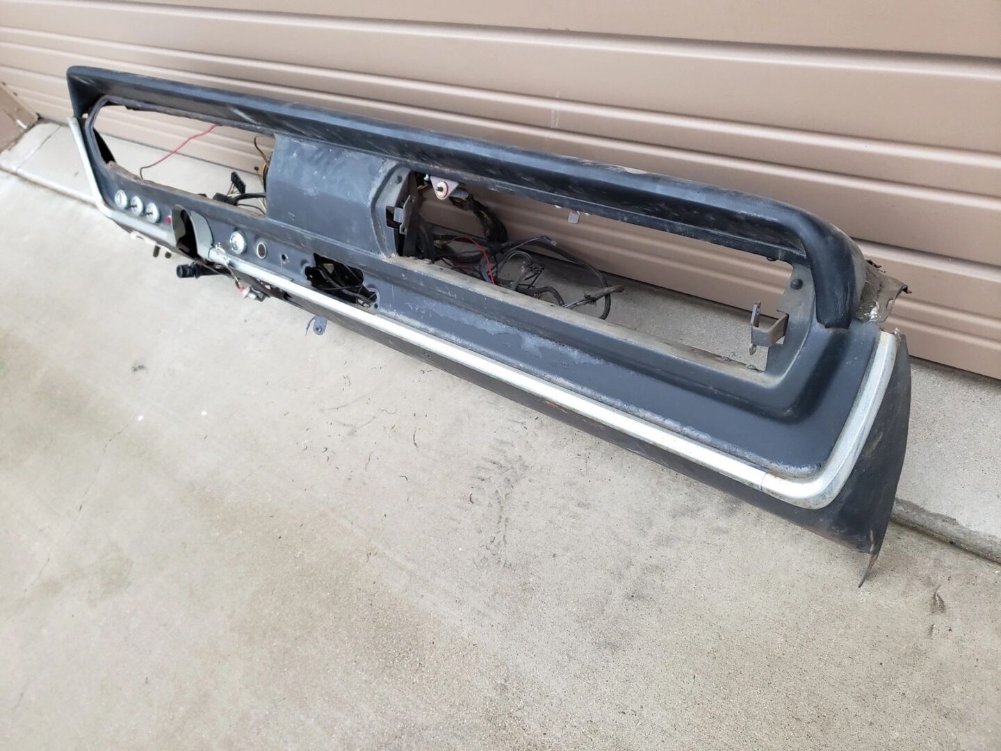 Car dashboard against a garage door background.