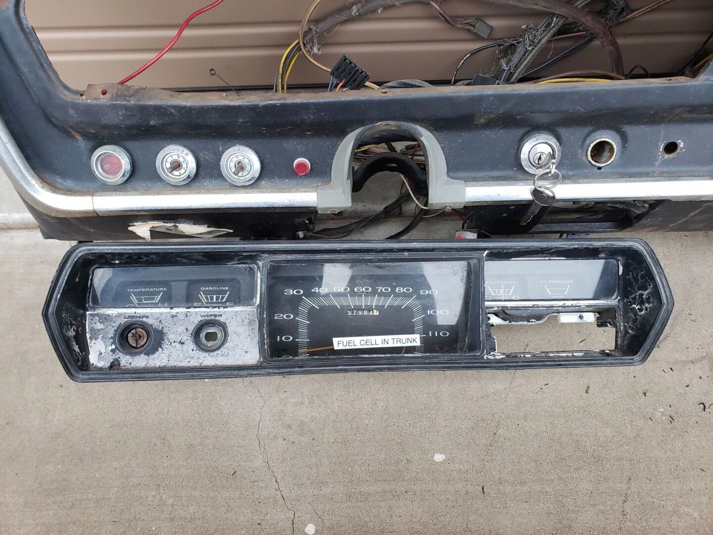 Old vehicle dashboard with speedometer removed.
