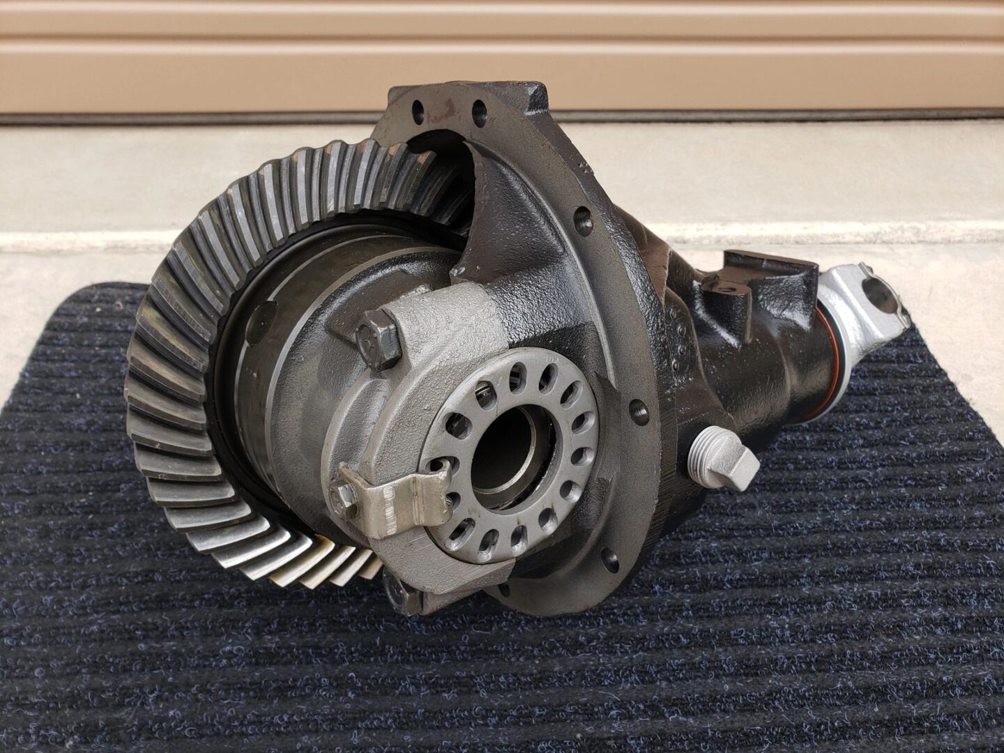 Automotive differential on a black mat.