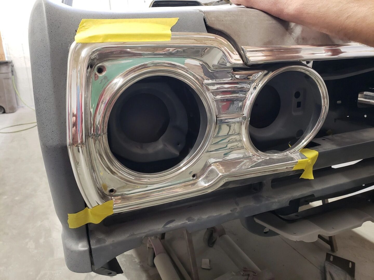 Car headlight frame with yellow tape.