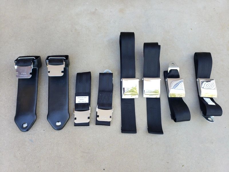 Black seatbelt buckles lined up on ground.