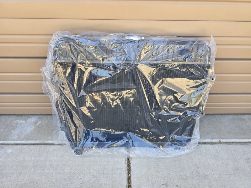 Plastic-wrapped radiator against a beige wall.