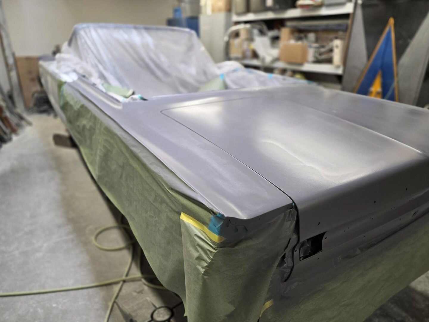Car undergoing restoration in a workshop.