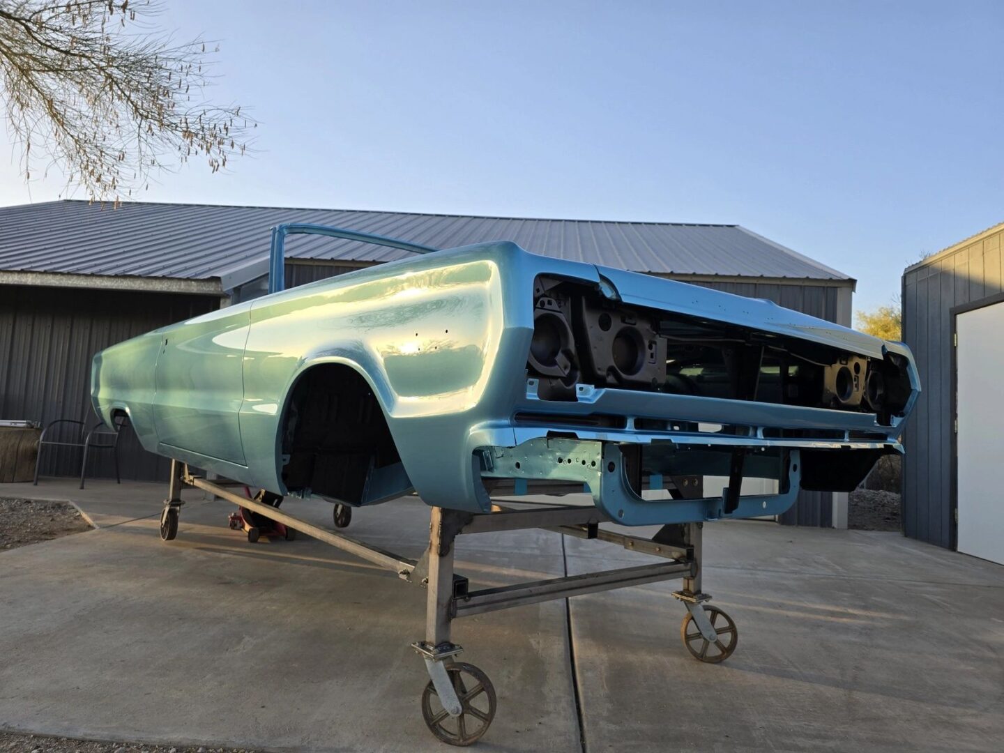 Vintage car body on a wheeled stand.