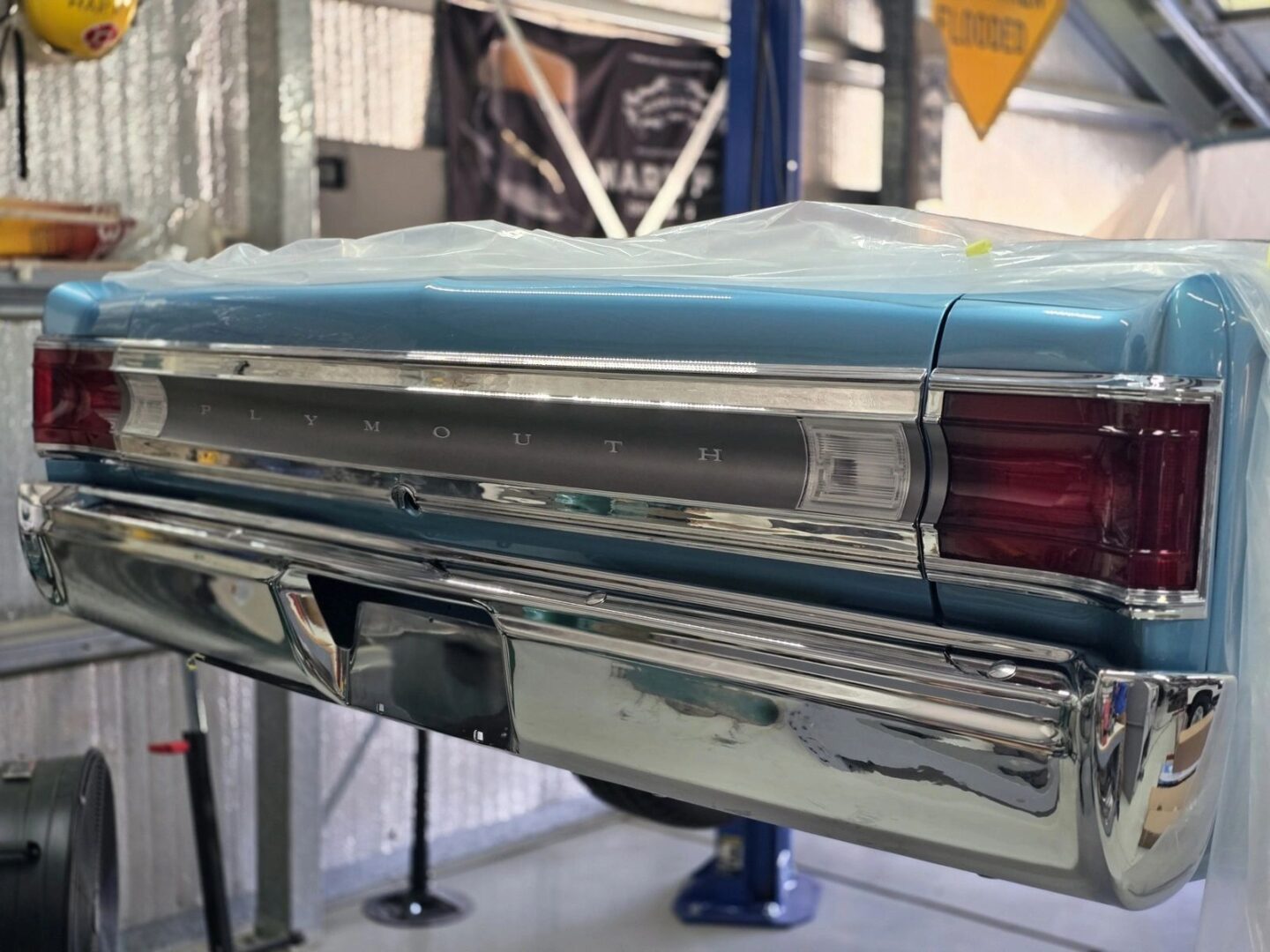 Classic Plymouth car rear in garage setting.