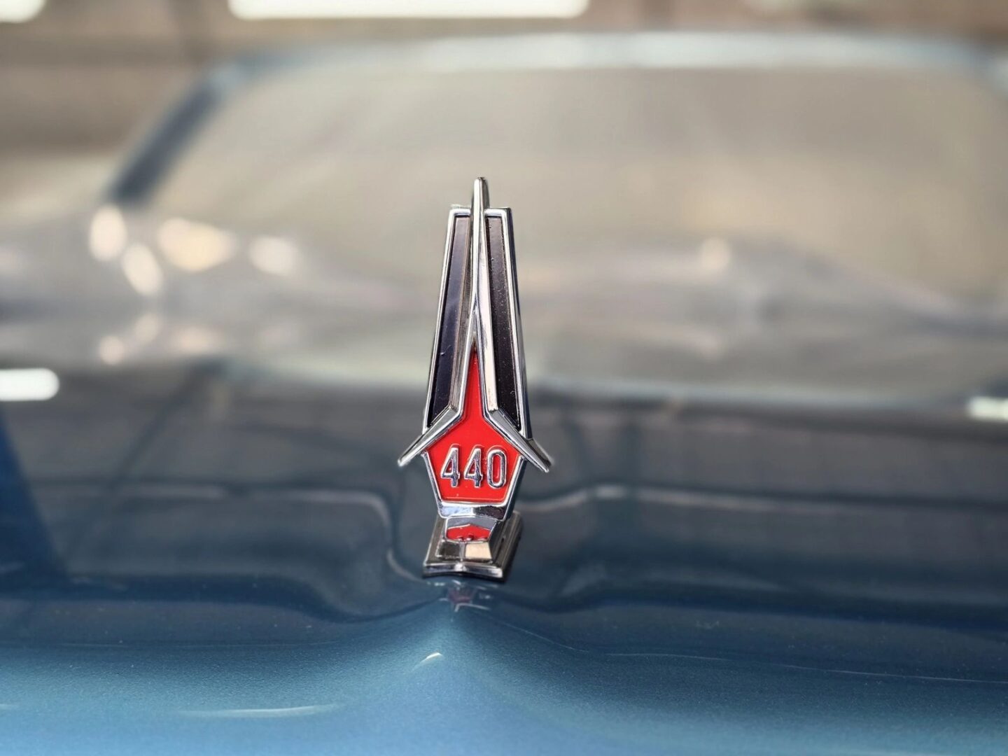 Car hood ornament with "440" emblem.