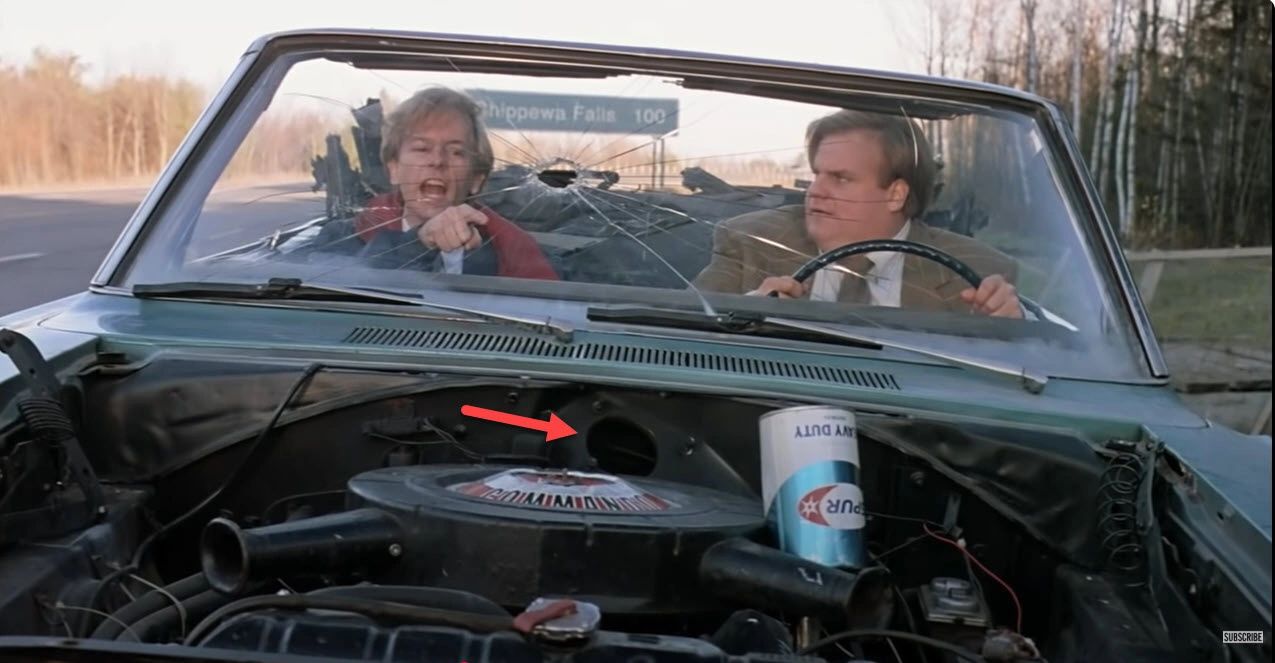 Two men driving a roofless car.