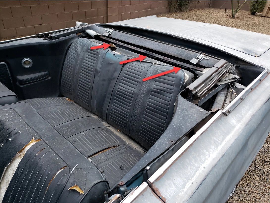 Convertible car interior with damaged backseat.