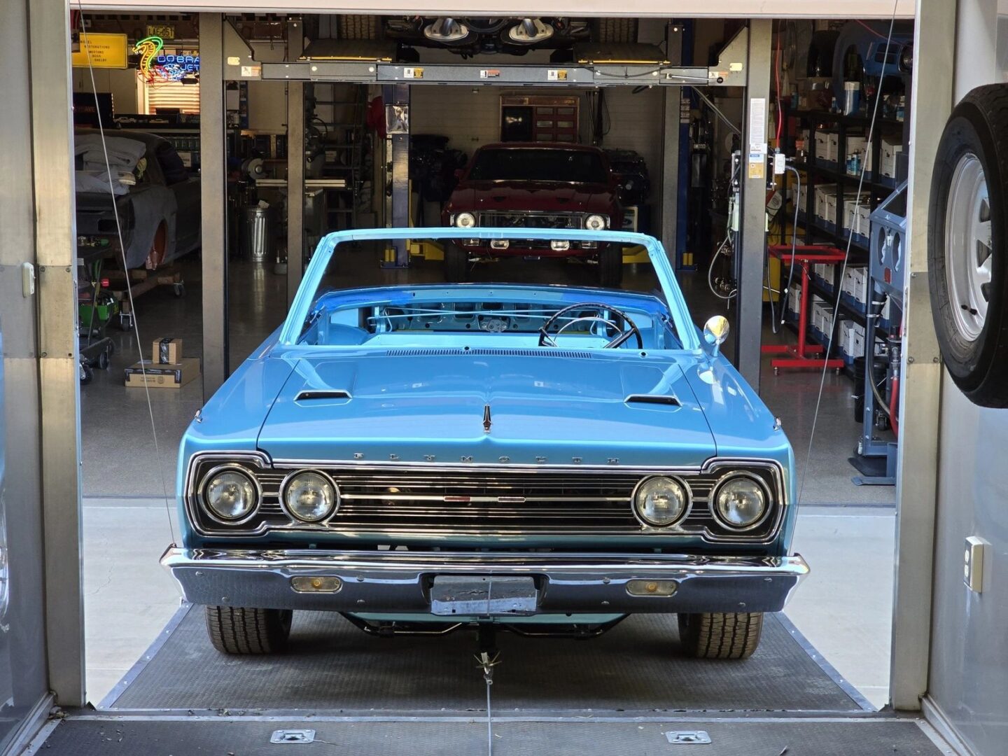 Blue vintage convertible car in a garage.