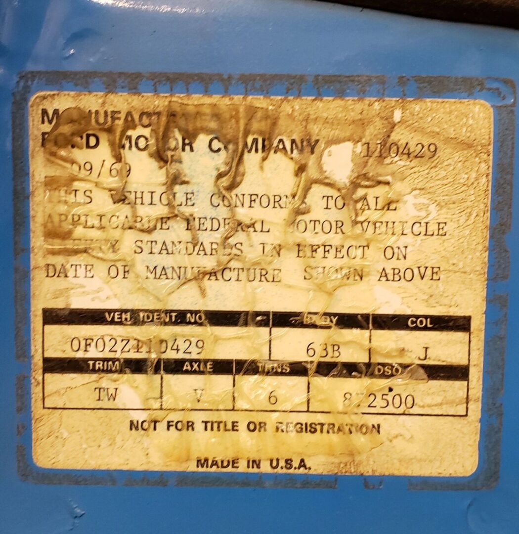 Vehicle identification sticker on blue surface.