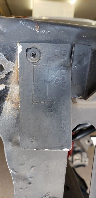 Metal plate attached to a car frame.