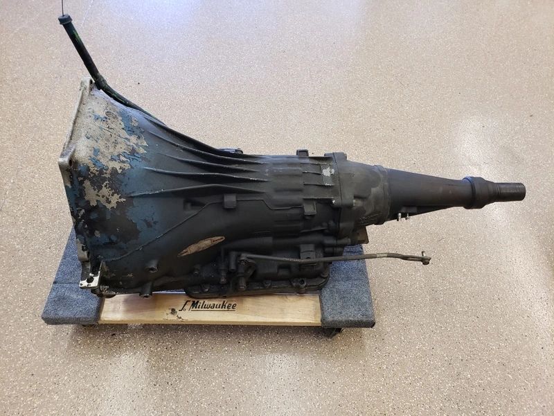 Old car transmission on wooden base.