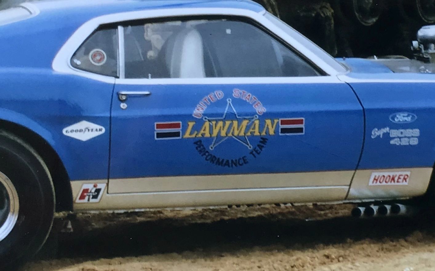 Blue vintage race car with "Lawman" logo.