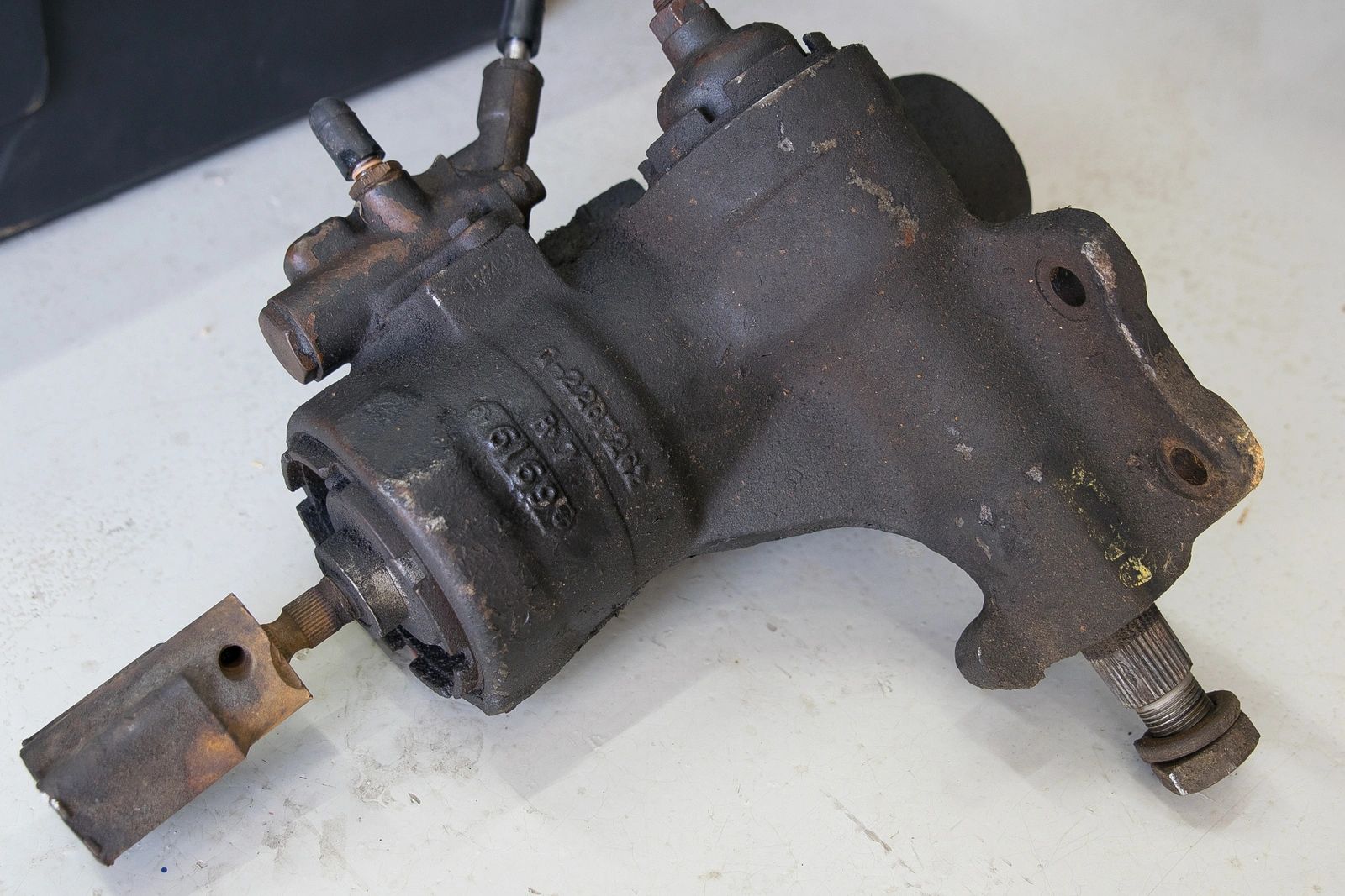 Old rusted mechanical part on white surface.