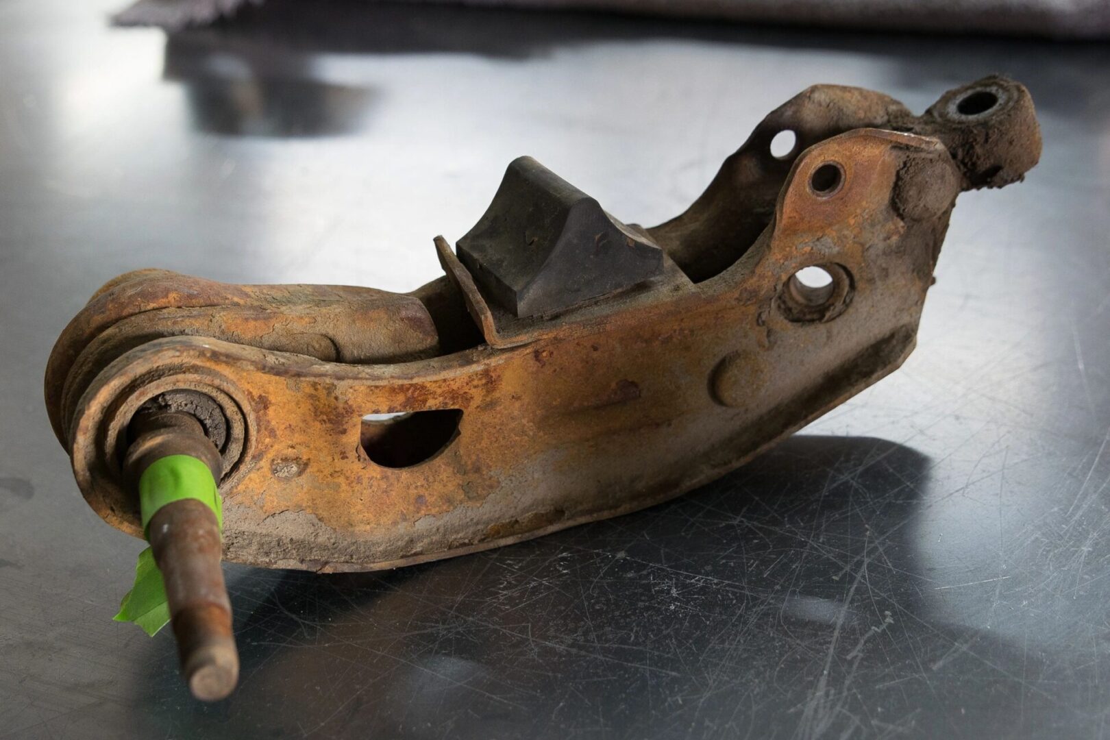 Rusty metal car part on a table.