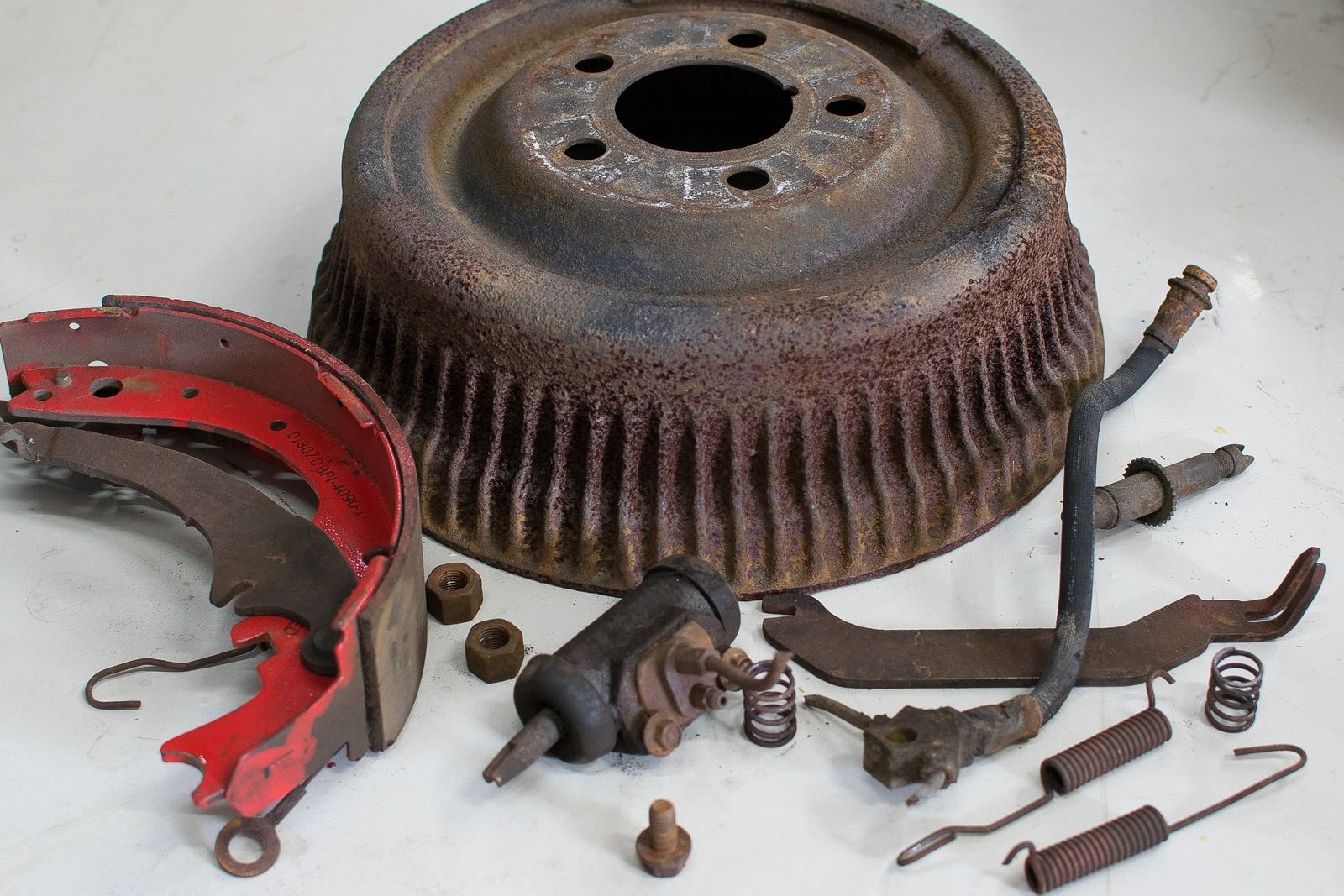 Rusty brake drum with disassembled parts.