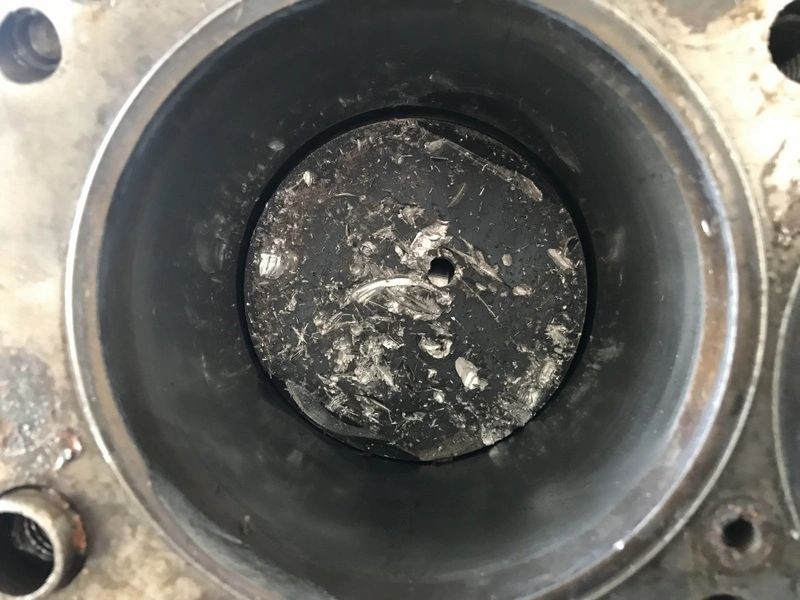 Damaged engine piston with visible debris.