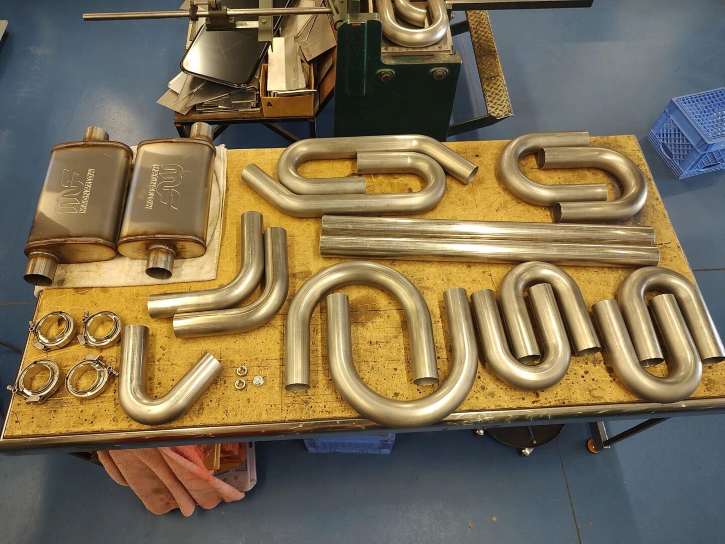 Metal exhaust pipes and components on table.